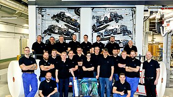 Mitarbeitende der RKW stehen stolz vor der neuen 10-Farben-Druckanlage