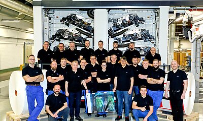 Mitarbeitende der RKW stehen stolz vor der neuen 10-Farben-Druckanlage